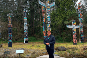 woman standing in front of totem poles - Talasay Tours