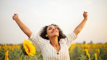 Woman with arms raised in a sunflower field