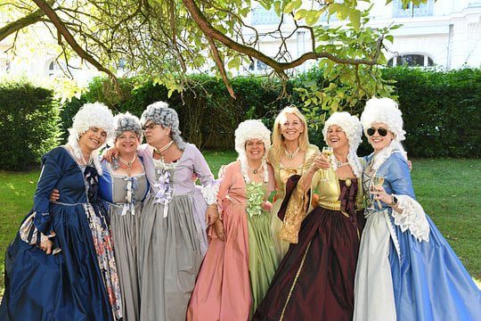 A group of women dressed in period gowns and wigs from the time of Marie Antoinette