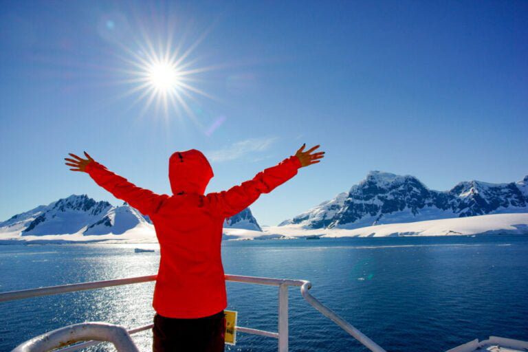 Woman watching the glacier in Antarctica from the boat
