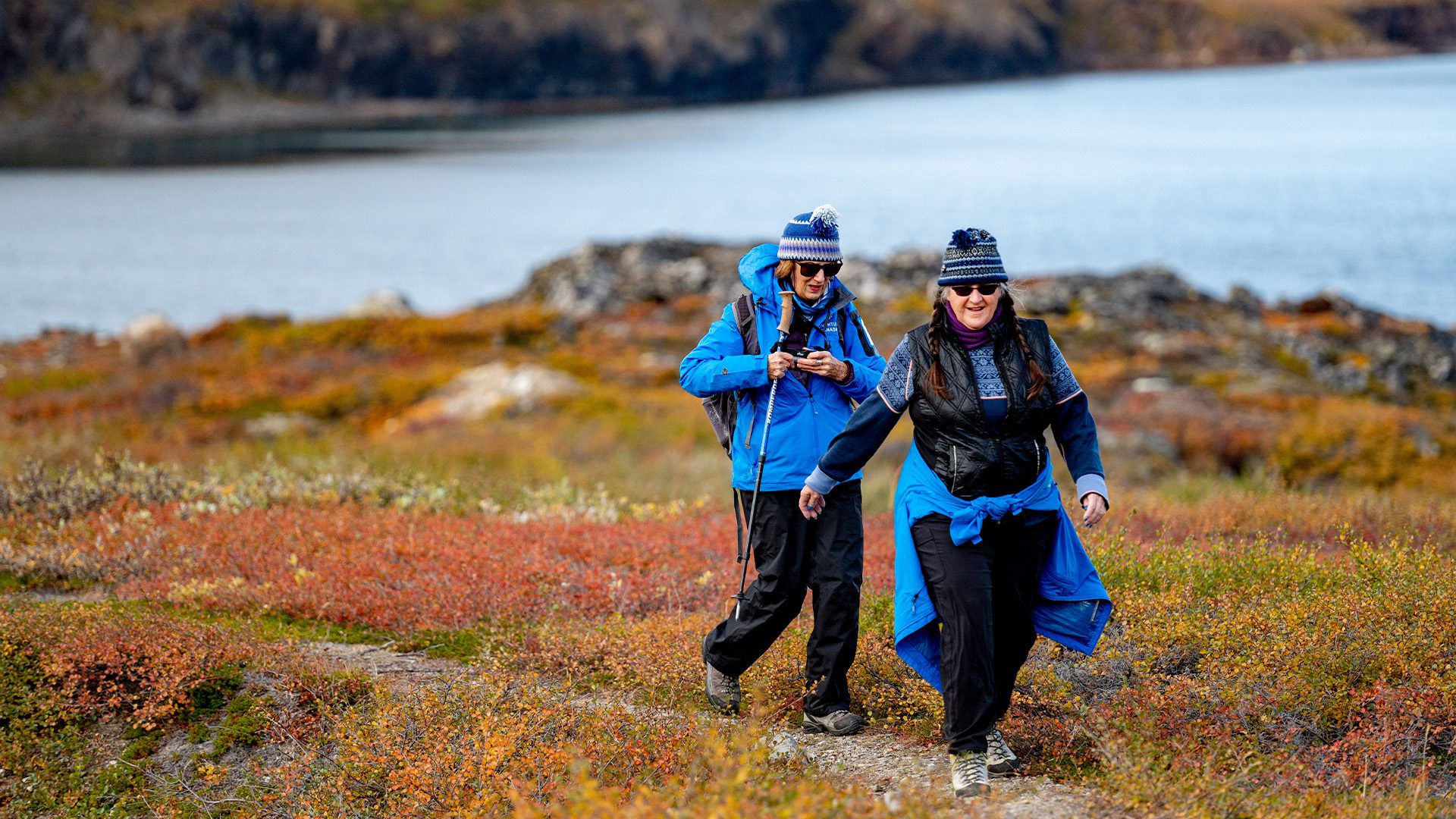 Two women hiking through colorful Arctic tundra