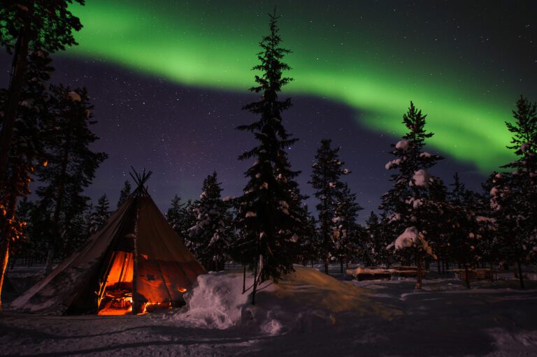 Northern Lights above tents at the reindeer lodge in Jukkasjärvi, Sweden