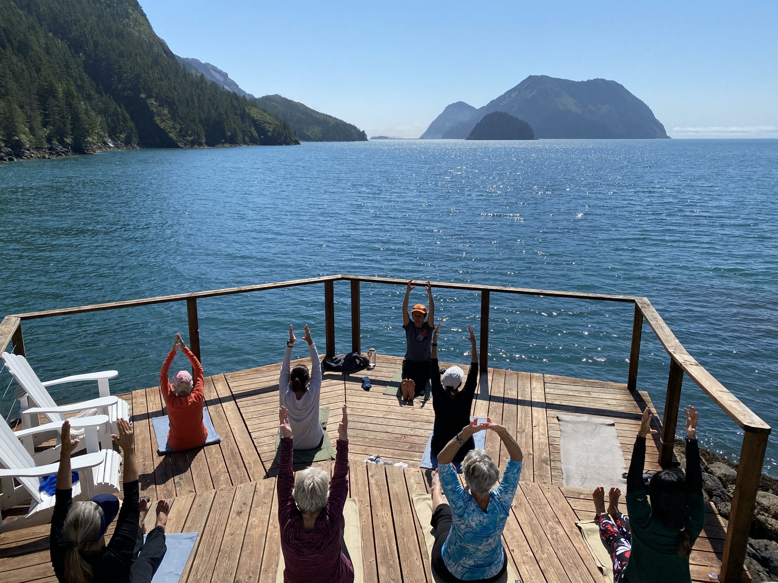 A group of women do yoga on a deck overlooking a lake in Alaska - Alaska: The Kenai Peninsula -Adventures in Good Company