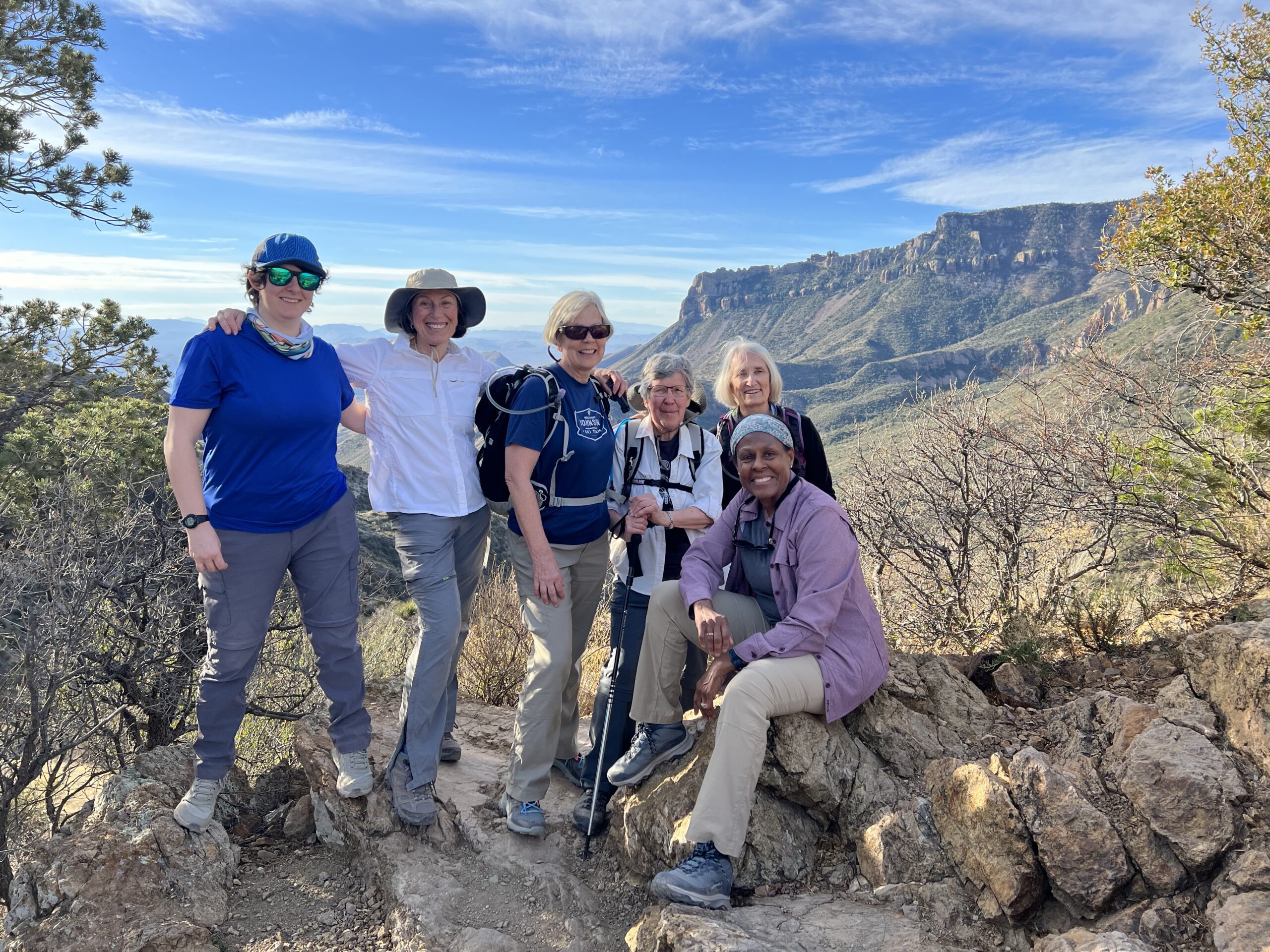 A smiling group of women pose for a photo with the picturesque mountains of the Big Bend region in the background - Big Bend Exploring and Hiking - Adventures in Good Company