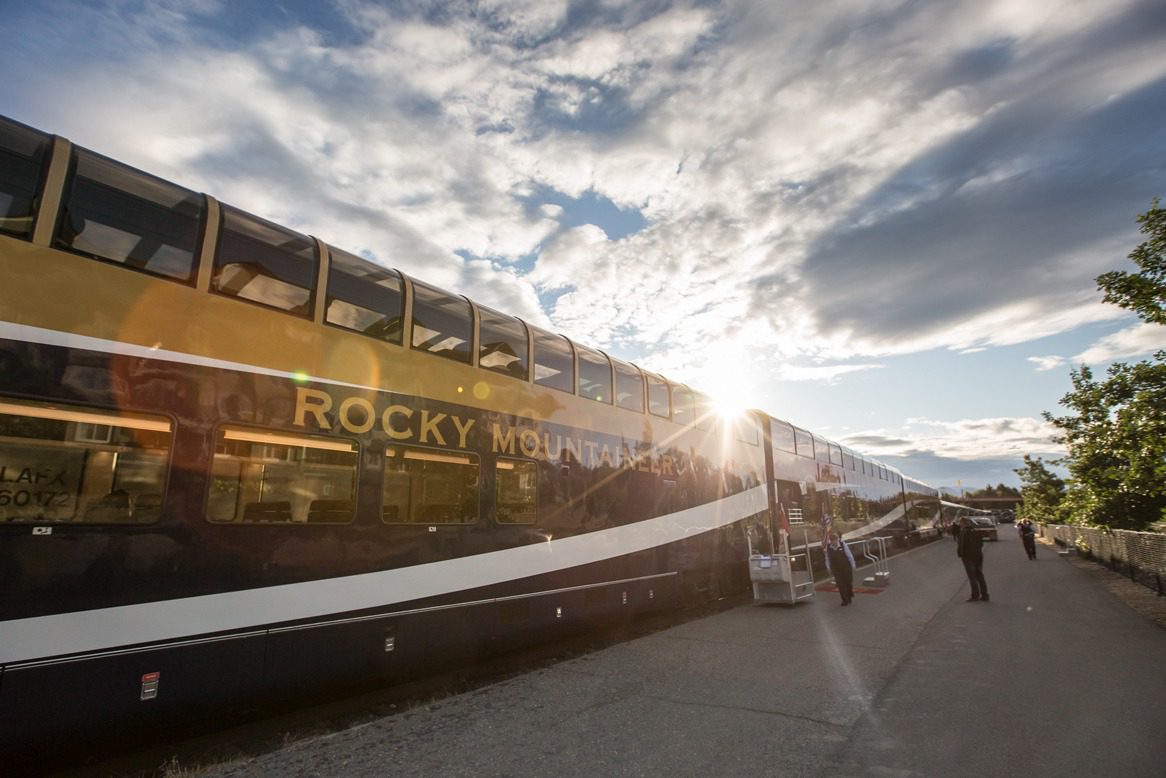 A side view of the Rocky Mountaineer train pulled up at a station at dusk - Canadian Adventurer Eastbound - Canada Rail Vacations