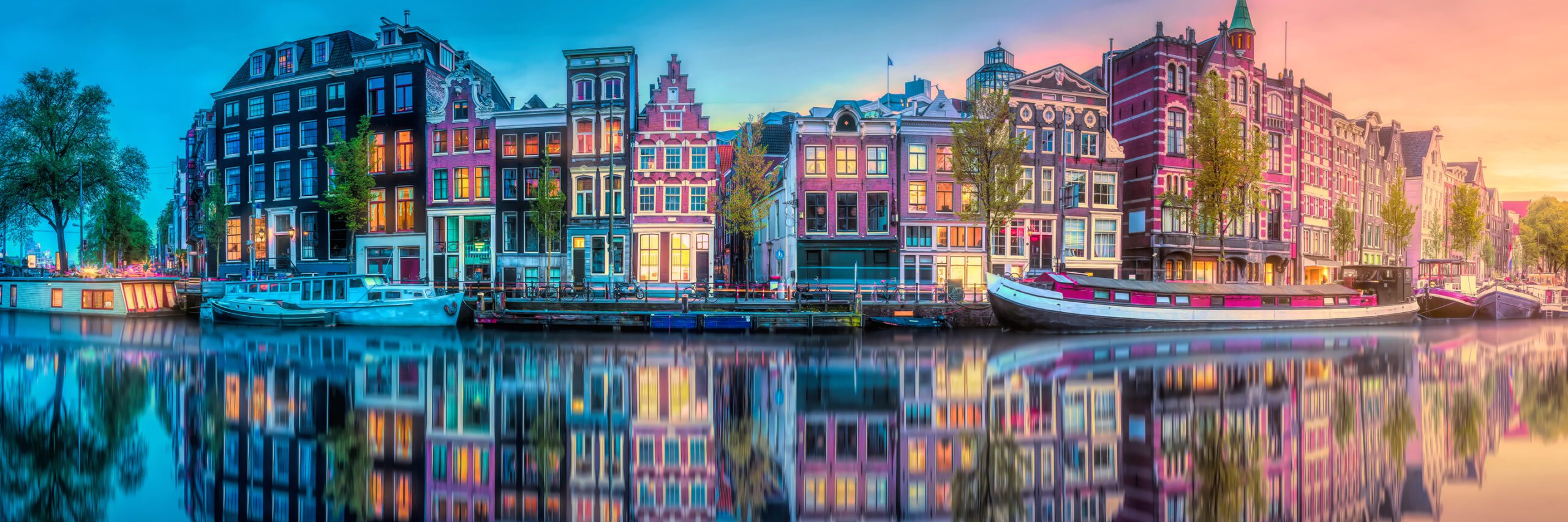 Kayaking through Amsterdam's picturesque canals, surrounded by vibrant, colorful houses at sunset - Active & Discovery on the Rhine - Avalon Waterways