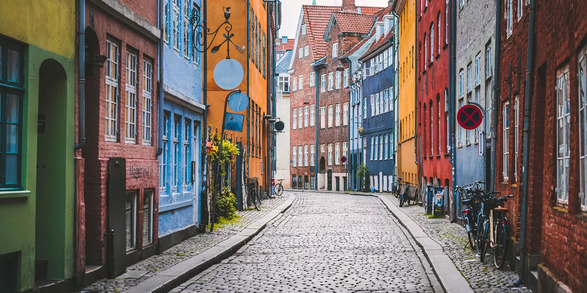 Vibrant row of colorful facades lining the charming streets of Copenhagen showcasing the city's lively and picturesque urban landscape - NORTHERN CAPITALS, A WOMEN-ONLY TOUR - Insight Tours
