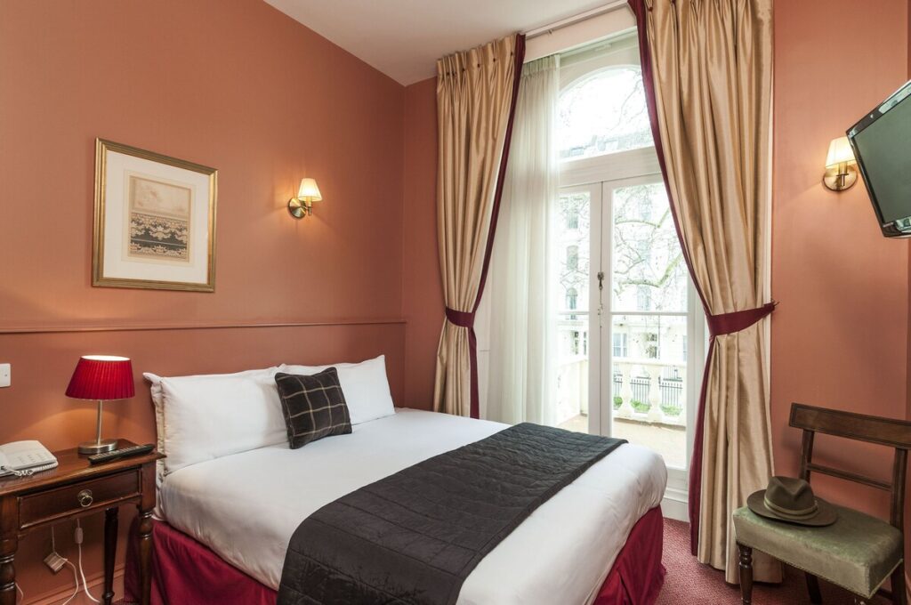 A simply decorated single room with double bed at the Victorian Rose Park Hotel in London, England, recommended as a safe place for women to stay by JourneyWoman readers.