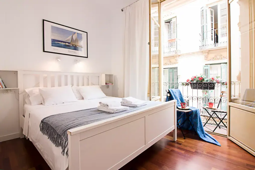 A queen room with a balcony viewing the street at FreshApartments by Bossh in Malaga, Spain, recommended by JourneyWoman readers as a safe place for women to stay.