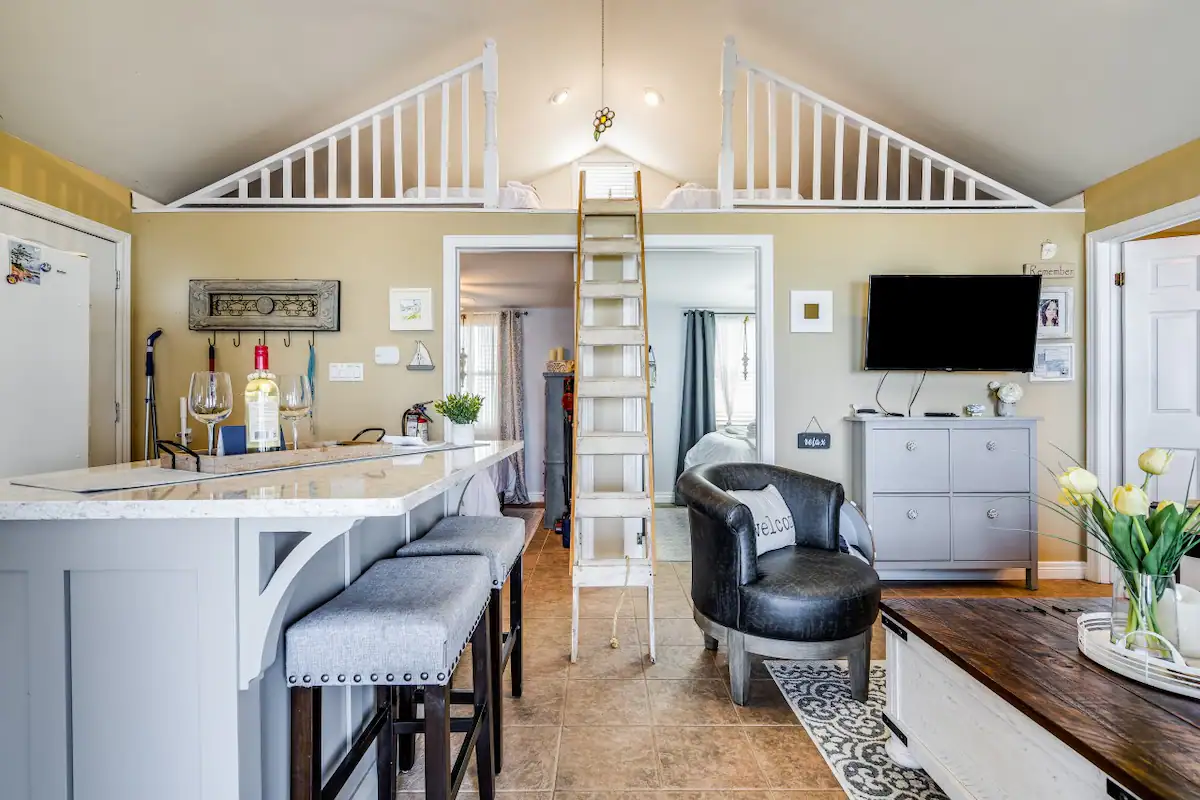 Well appointed sitting area with ladder to the loft of the Julia Kennedy Beach House in Leamington, Ontario, recommended as a safe place for women to stay.