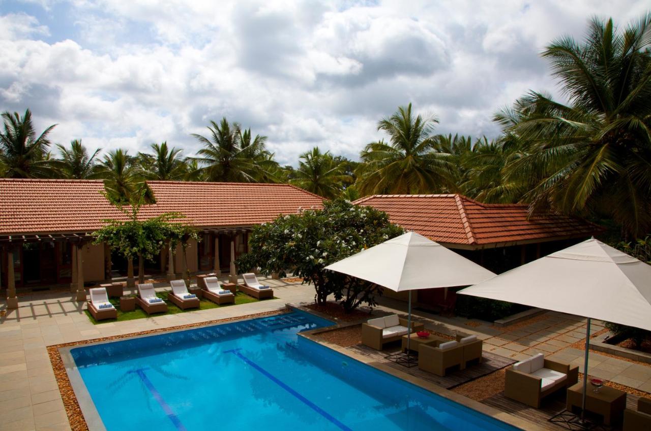 A peaceful poolside scene at the Shreyas Yoga Retreat in Bangalore, India, recommended as a safe place for women to stay.