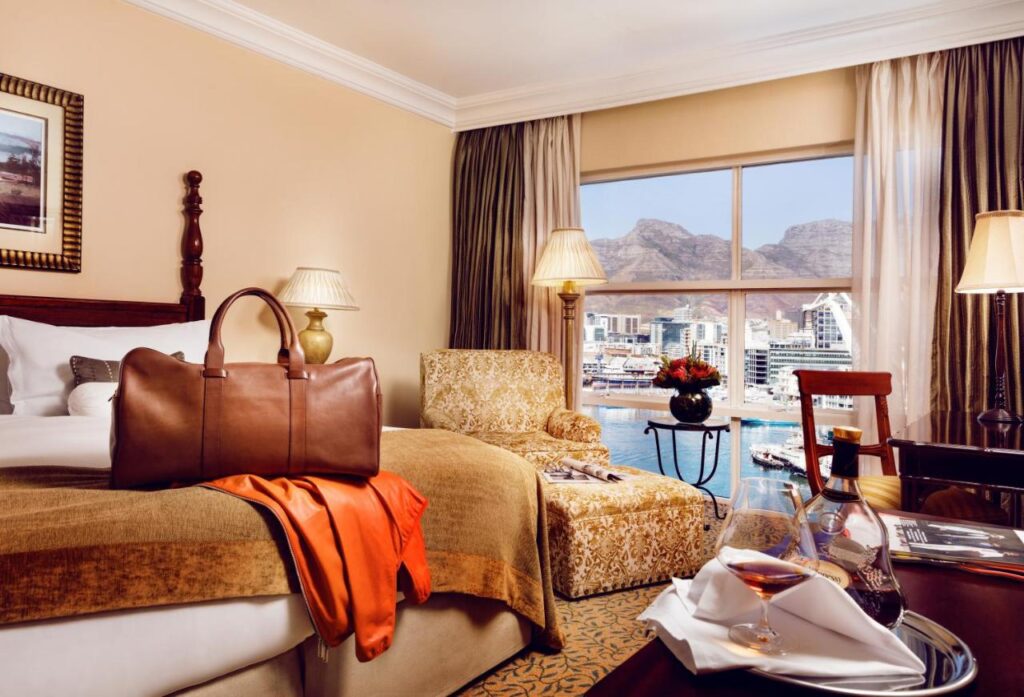 A beautiful room with a double bed and a view of the waterfrton at the Table Bay Hotel in Cape Town, South Africa, recommended as a safe place for women to stay by a JourneyWoman reader.