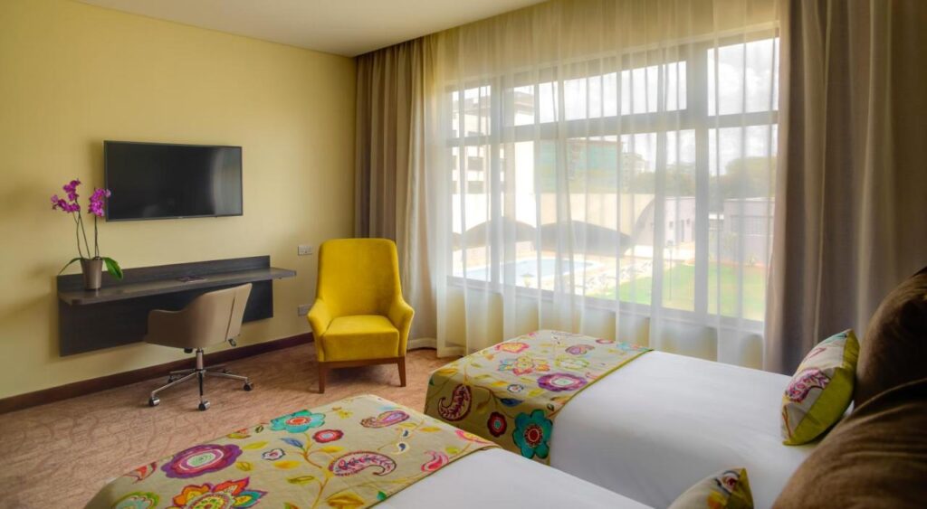 A simple twin bed room with bright yellow accents at the Tamarind Tree Hotel in Nairobi, Kenya.