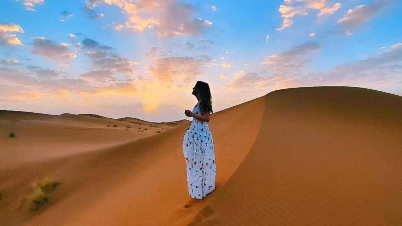 A woman overlooking the Sahara Desert - Morocco Delivered -Asgunfa Travel Morocco