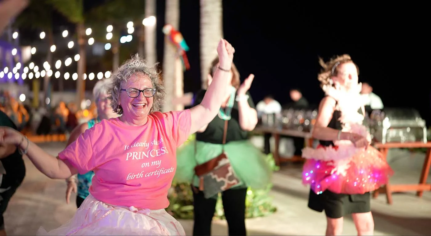 A group of women joyfully dancing at night during the Girlfriends Getaway 2024.