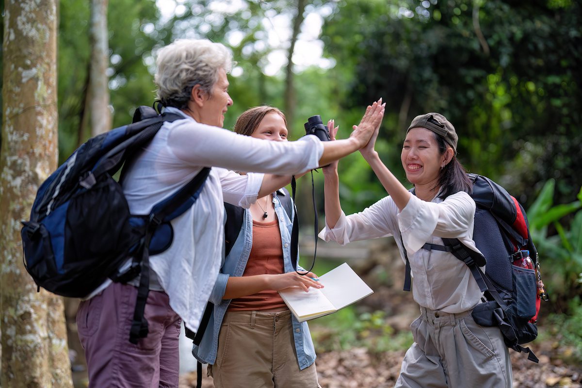 Backpack tourist travel outdoor adventure bird study using binoculars looking and record to book