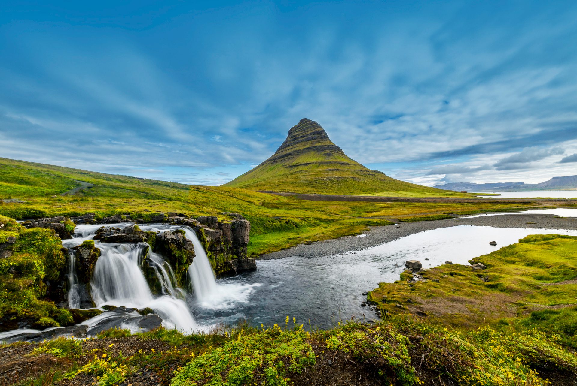 A stunning view of Kirkjufell mountain and the lush green landscape - Iceland's Westfjords & North Coast