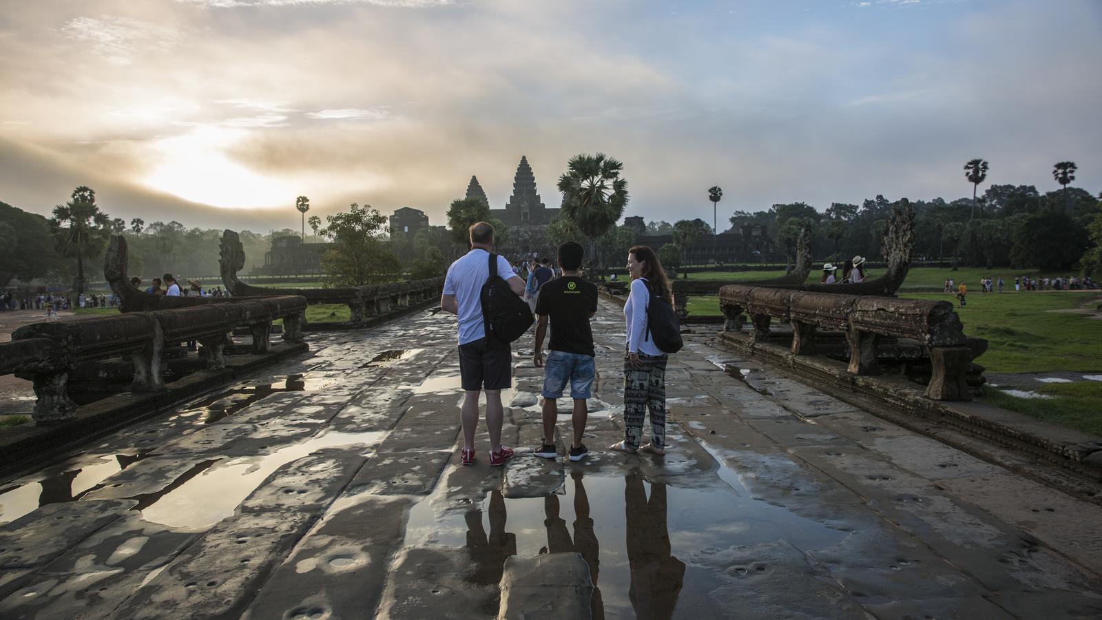 Travelers admire the ancient stone architecture of Angkor Wat