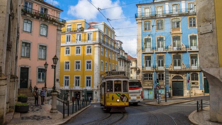 Two trams passing through the colorful streets of Lisbon, surrounded by vibrant buildings and historic charm