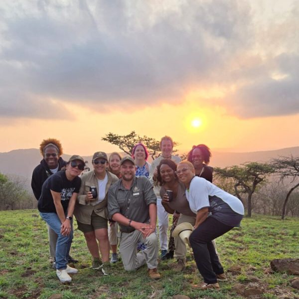 Tour participant capturing a memorable moment during a stunning sunset - South African Splendors