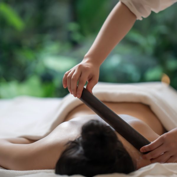 Relaxed woman receiving a massage at a luxurious resort spa, surrounded by a serene ambiance.