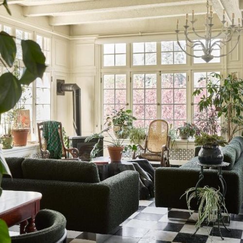 Inviting communal area of the Blind Tiger Burlington, a Lark Hotel in Vermont, with floor to ceiling windows and eclectic furniture, considered a safe place for women to stay.