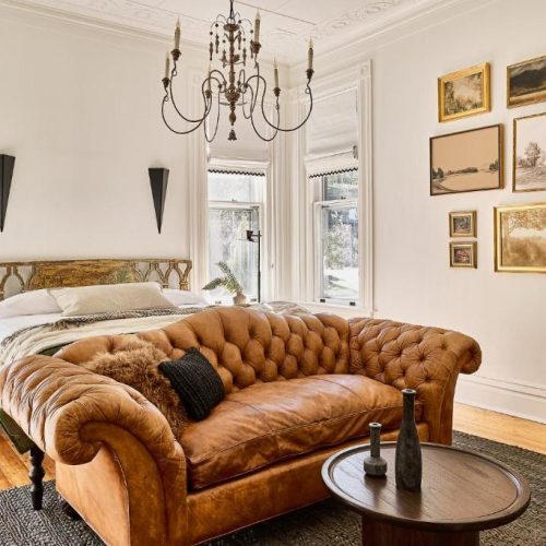 A well lit corner suite at the Blind Tiger Burlington, a Lark Hotels guest house in Vermont, with double bed and comfortable couch, considered a safe place for women to stay.