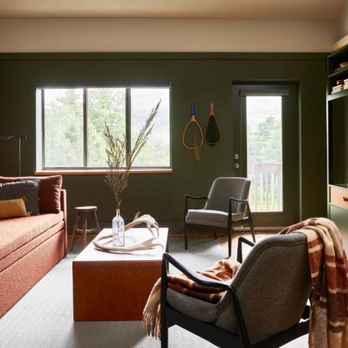 Comfortable seating area with couch and side chairs in a suite at Hunter Lodge, a Bluebird by Lark hotel in Hunter, New York, a safe place for women to stay.