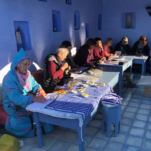 Women sitting together a long table - Writers Journey
