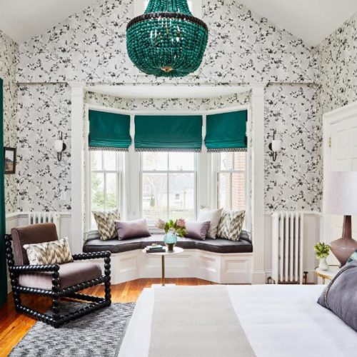 Double bed suite with bay window and floral wallpaper at The Cliffside Inn by Lark Hotels in Newport, Rhode Island, a safe place for women to stay.