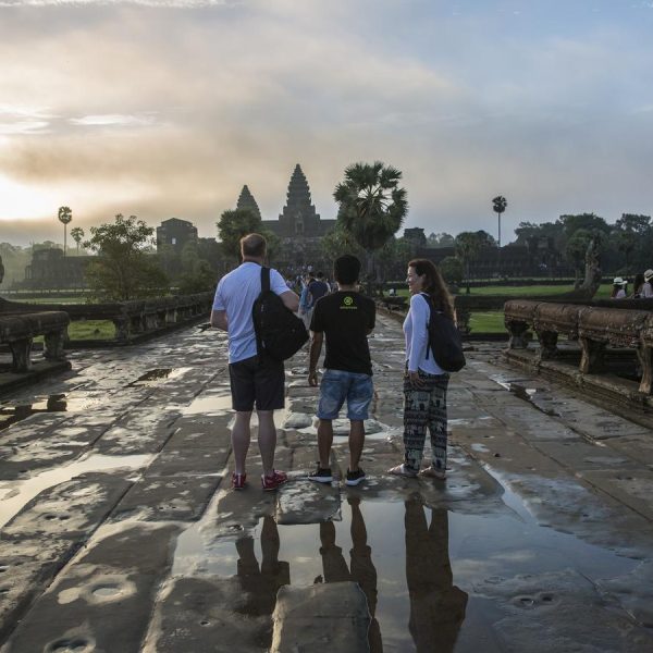 Travelers admire the ancient stone architecture of Angkor Wat