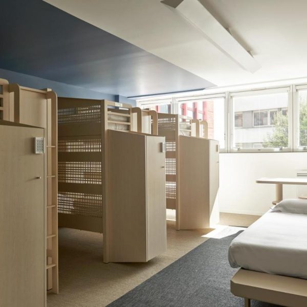 Multiple twin beds separated by privacy screens show one of the sleeping options at luxury hostel FIAP Jean Monnet in Paris, France. Recommended by a reader of the Women's Travel Directory.