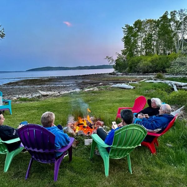 Group of women relaxing together by a cozy fire pit on a calm afternoon - Spirit of Watercolor in Maine