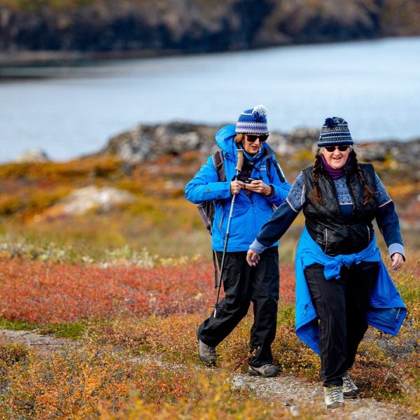 Two women hiking through colorful Arctic tundra