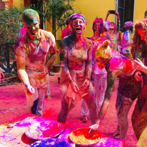Group of women covered in coloured powder celebrating Holi in India - India for Beginners