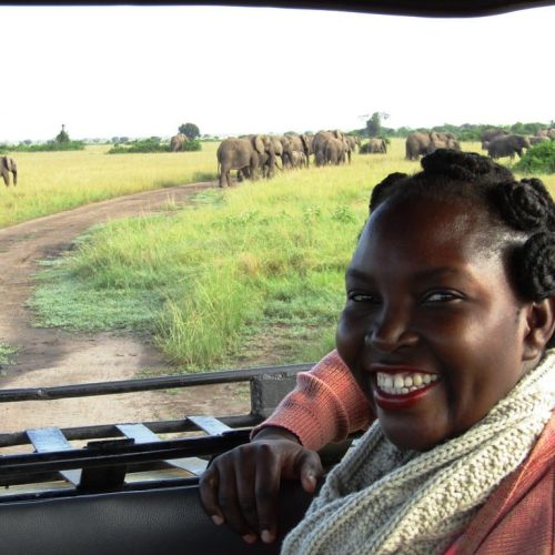 Irene Nalwoga, CEO Women Tour Uganda, with elephants in the background