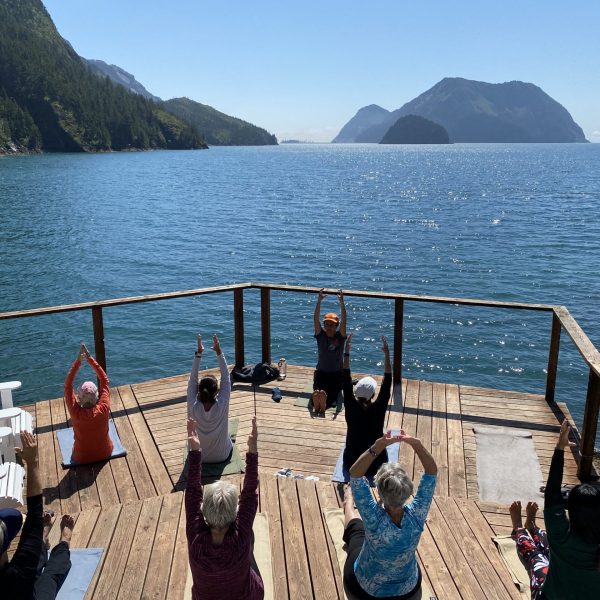 A group of women do yoga on a deck overlooking a lake in Alaska - Alaska: The Kenai Peninsula -Adventures in Good Company