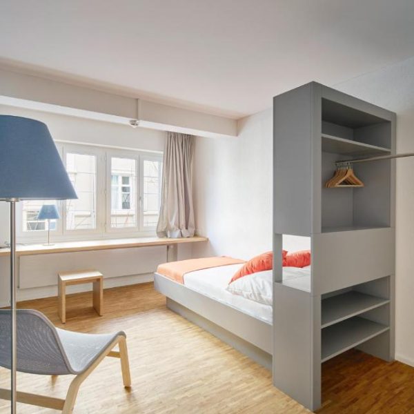 A simple room with a single bed and lots of natural light at the women-only Josephine Guesthouse in Zurich, Switzerland, a safe place for women to stay.