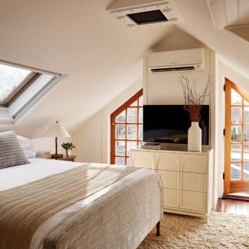 A bright and modern attic room with walkout porch at the Kennebunkport Captains Collection in Kennebunkport, Maine, a safe place for women to stay.