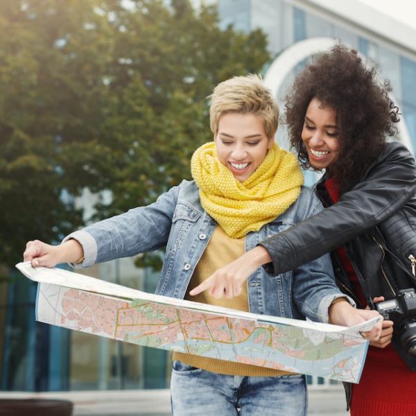 Two women looking at a map while travelling.