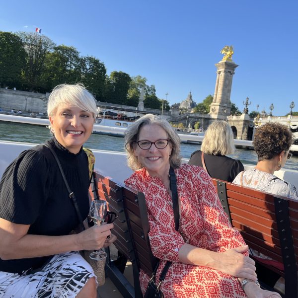 Two women enjoying the sunset cruise on Seine - Insider Tour of Paris Neighborhoods