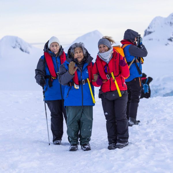 Women dressed in full winter gear pose for a photo on excursion as part of the Antarctic Expedition for Aurora Expeditions