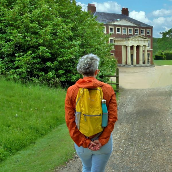 Woman gazing at the elegant stately manor of Goodnestone Park.