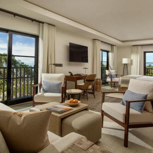 Bedroom suite with seating area at the Stilwell by Lark Hotels in Carmel, California, a safe place for women to stay.