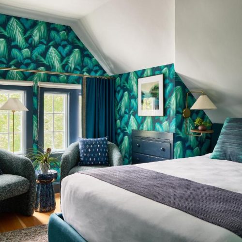 A double bed suite with modern wallpaper at the Coco Edgartown Collection by Lark Hotels in Edgartown, Martha's Vineyard, recommended as a safe place for women to stay.