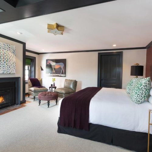 A simple but tasteful bedroom suite at The Merchant Salem, a Lark Hotel and a safe place for women to stay in Salem, Massachusetts.