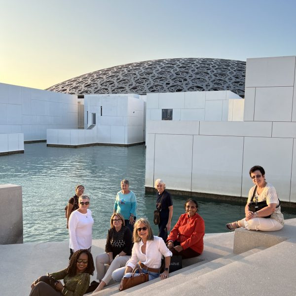 A women-only travel group poses in front of the Abu Dhabi Louvre - The Women's Travel Group