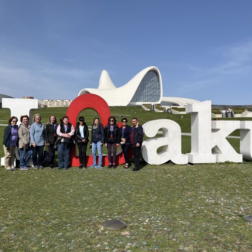 A women-only tour group stands in front of a life-sized Baku sign - The Women's Travel Group