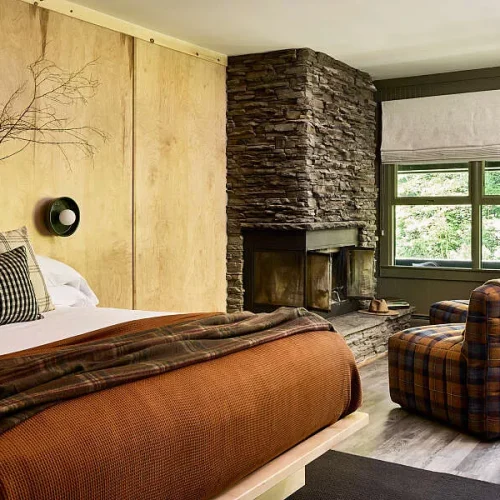 A room with a king bed and rustic decorations at the Bluebird Caddy Hill Hotel in Stowe, Vermont