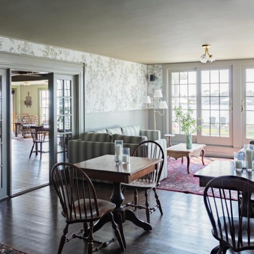 The restraunt/dining area with small tables and a cozy nook at the Bluebird Ocean Point Hotel in East Boothbay, Maine.